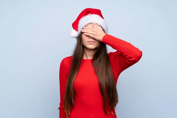Dívka Vánočním Kloboukem Přes Izolované Modré Pozadí Zakrývající Oči Rukama — Stock fotografie