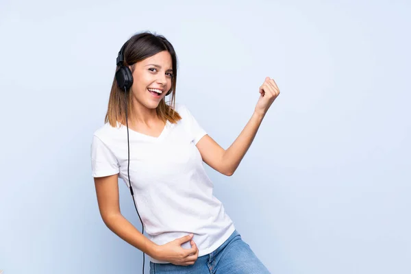 Jeune Femme Sur Fond Bleu Isolé Utilisant Mobile Avec Écouteurs — Photo