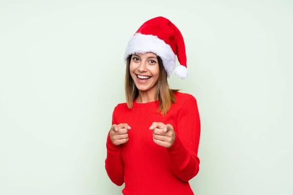 Meisje Met Kerst Hoed Geïsoleerde Groene Achtergrond Wijst Vinger Naar — Stockfoto