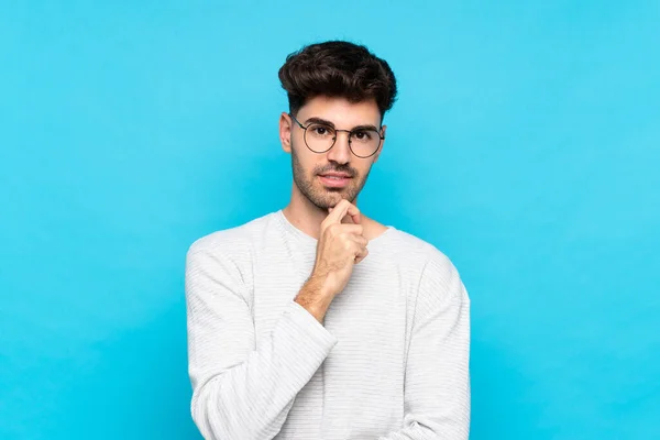 Joven Sobre Fondo Azul Aislado Con Gafas Sonriendo — Foto de Stock