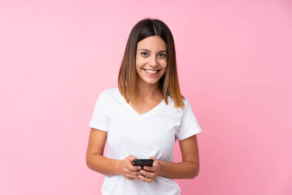 Jovem Sobre Fundo Rosa Isolado Enviando Uma Mensagem Com Celular — Fotografia de Stock