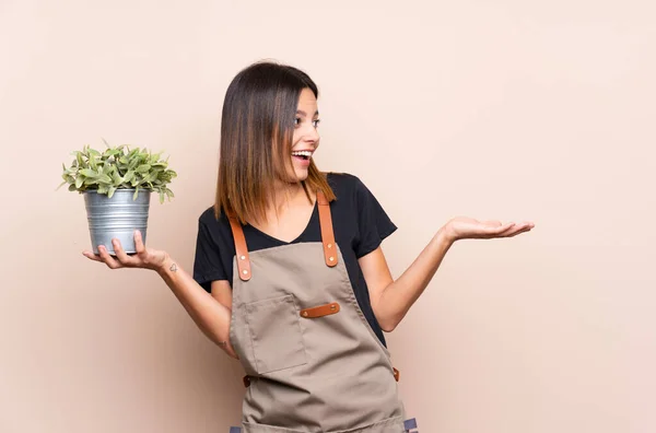 Jonge Vrouw Met Een Plant Met Verrassing Gezichtsuitdrukking — Stockfoto