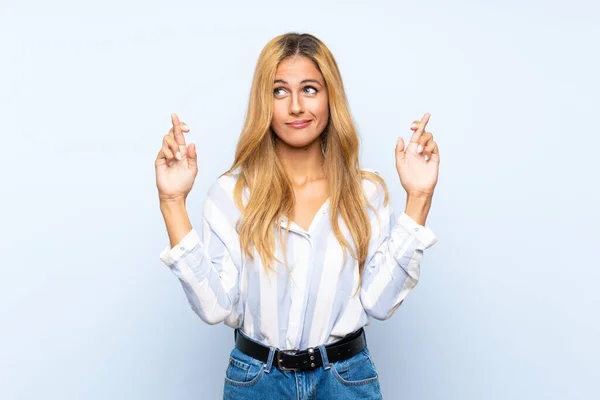 Young Blonde Woman Isolated Blue Background Fingers Crossing Wishing Best — Stock Photo, Image