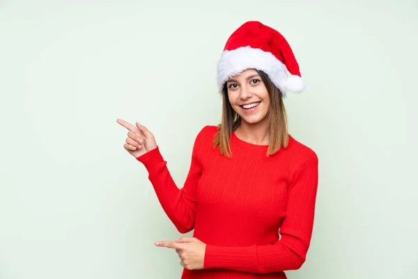 Zole Edilmiş Yeşil Arka Planda Noel Şapkası Takmış Bir Kız — Stok fotoğraf