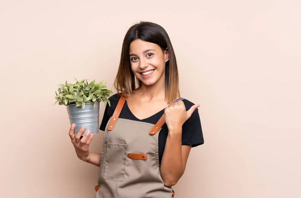 Jonge Vrouw Met Een Plant Die Naar Zijkant Wijst Een — Stockfoto