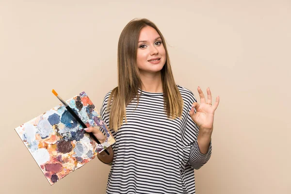 Dziewczyna Nastolatek Trzyma Paletę Białym Tle Pokazując Znak Palcami — Zdjęcie stockowe