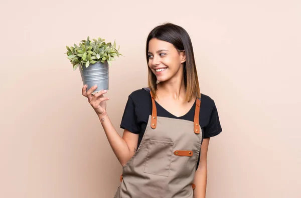 Ung Kvinna Som Håller Växt Med Glada Uttryck — Stockfoto