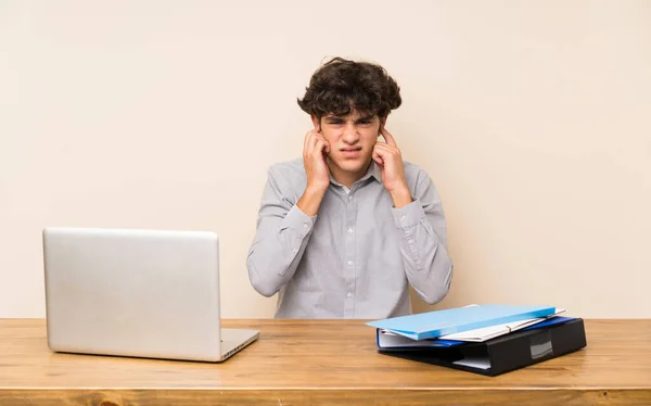 Jovem Estudante Com Laptop Frustrado Cobrindo Orelhas — Fotografia de Stock