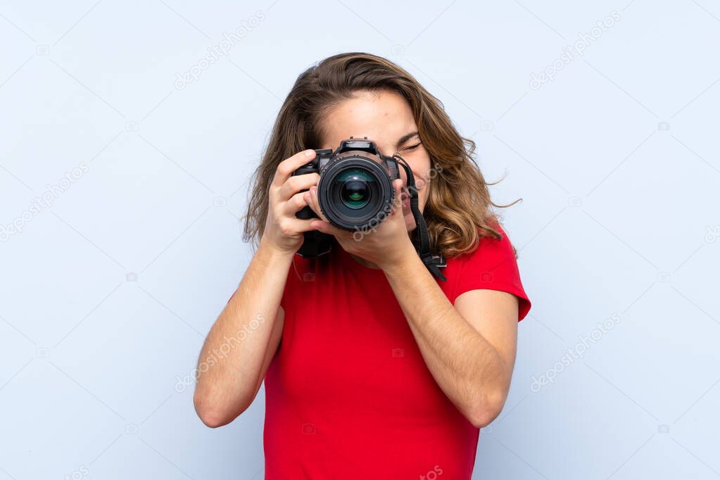 Young blonde woman with a professional camera