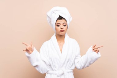 Tecrit edilmiş arka planda bornozlu genç kız, yan taraftakilerin şüpheye düştüğünü gösteriyor.