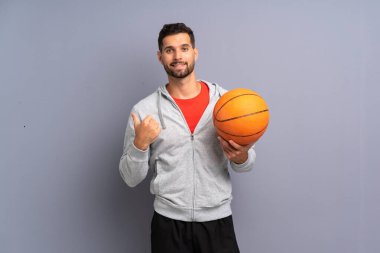 Yakışıklı genç basketbolcu bir ürün sunmak için yan işaret