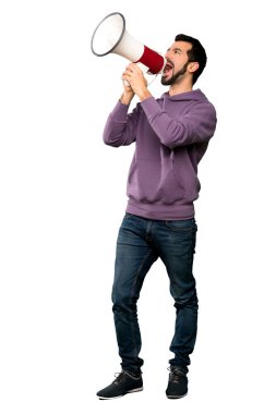 Yakışıklı bir megafon ile izole beyaz arka plan üzerinde bağırarak kazak ile tam uzunlukta atış