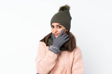 Kışlık şapkalı genç kız izole edilmiş beyaz bir arka plan üzerinde bir fikir düşünüyor.