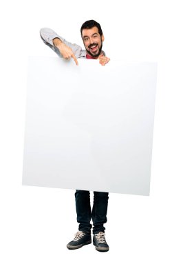 Boş bir afişini izole beyaz arka plan üzerinde tutarak sakallı yakışıklı adam tam uzunlukta atış