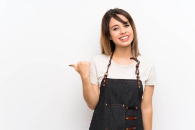 Önlüklü genç bir kadın bir ürün sunmak için kenarı işaret ediyor.