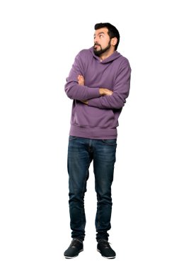 Sweatshirt 'lü yakışıklı bir adamın omuzlarını izole edilmiş beyaz arka plan üzerinden kaldırırken şüpheli hareketler yaptığı uzun bir çekim.