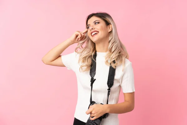 Menina Adolescente Sobre Fundo Rosa Isolado Com Uma Câmera Profissional — Fotografia de Stock