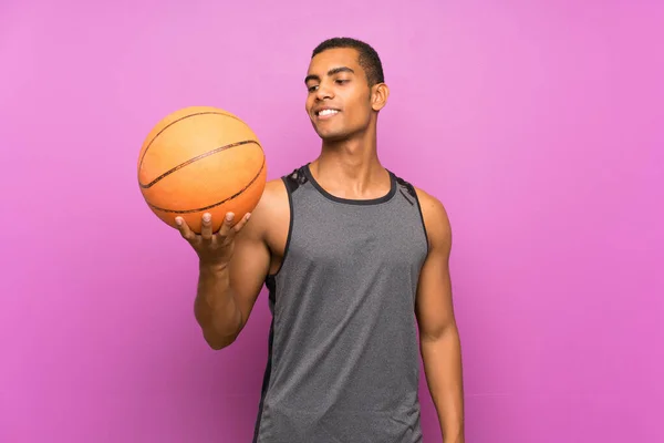 Молодой Спортсмен Мячом Баскетбола Над Изолированной Фиолетовой Стеной Счастливым Выражением — стоковое фото