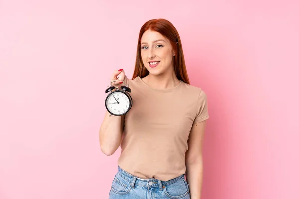 Jonge Roodharige Vrouw Geïsoleerde Roze Achtergrond Met Vintage Wekker — Stockfoto