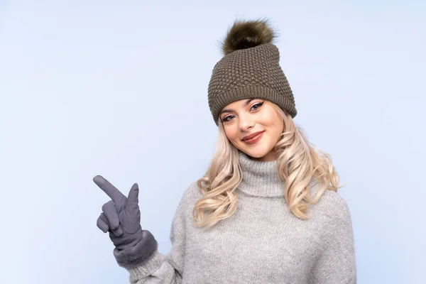 Giovane Ragazza Adolescente Con Cappello Invernale Sfondo Blu Isolato Puntando — Foto Stock