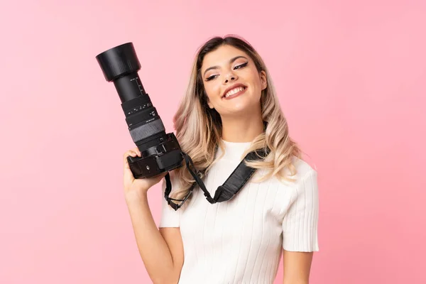 Adolescente Chica Sobre Aislado Rosa Fondo Con Una Cámara Profesional —  Fotos de Stock