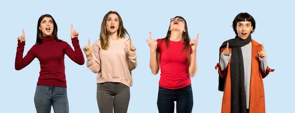 Conjunto Mulheres Sobre Fundo Azul Isolado Surpreso Apontando Para Cima — Fotografia de Stock