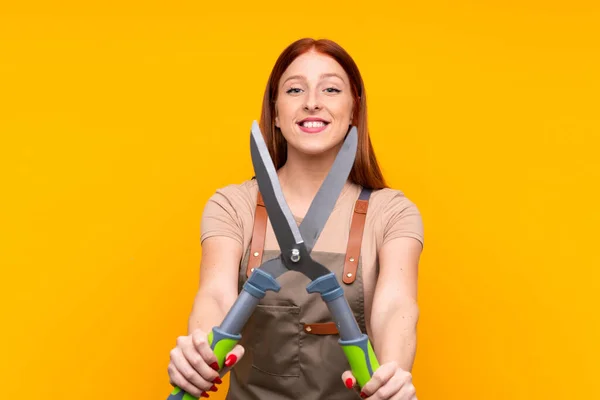 Jonge Roodharige Tuinman Vrouw Met Snoeischaar Geïsoleerde Gele Achtergrond — Stockfoto