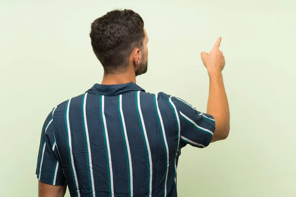 Knappe Man Geïsoleerde Achtergrond Wijzend Terug Met Wijsvinger — Stockfoto