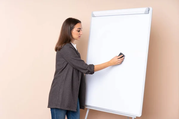 Young woman giving a presentation on white board giving a presentation on white board
