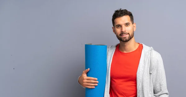 Joven deportista con esterilla — Foto de Stock