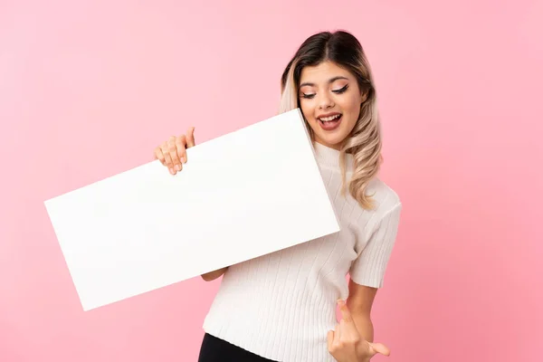 Chica Adolescente Sobre Fondo Rosa Aislado Sosteniendo Cartel Blanco Vacío — Foto de Stock