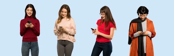 Conjunto Mujeres Sobre Fondo Azul Aislado Enviando Mensaje Con Móvil — Foto de Stock