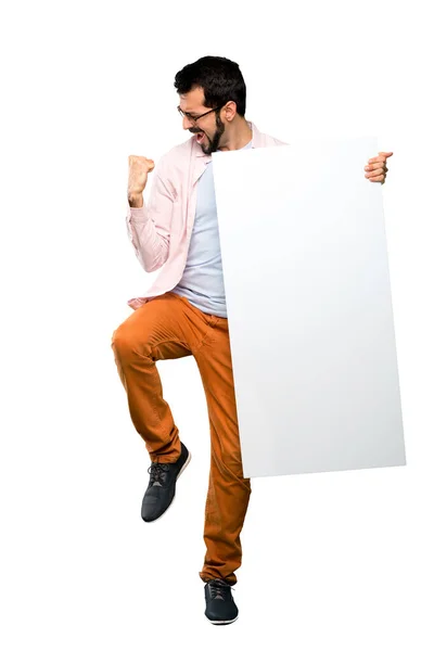 Homem bonito com barba segurando um cartaz vazio — Fotografia de Stock