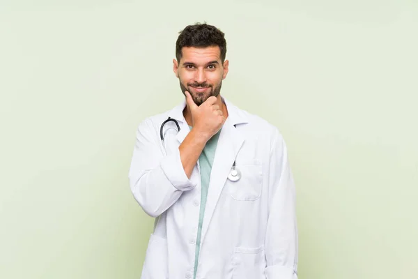 Jovem Médico Homem Sobre Isolado Parede Verde Rindo — Fotografia de Stock