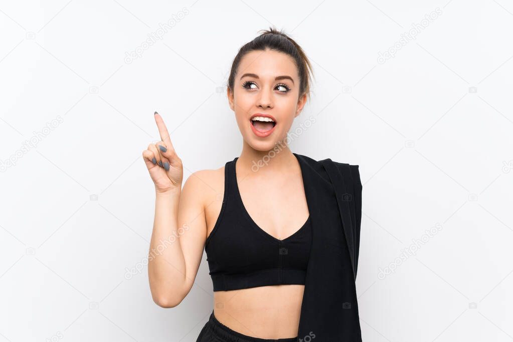 Young sport woman over white wall intending to realizes the solution while lifting a finger up