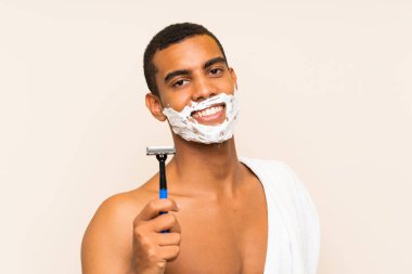 Genç yakışıklı adam mutlu ifade ile izole arka plan üzerinde sakalTıraş