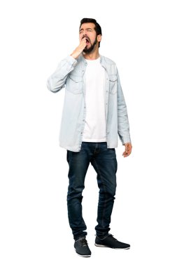 Sakallı, esneyen ve ağzı açık, elleri izole edilmiş beyaz arka planı olan yakışıklı bir adamın tam boy fotoğrafı.