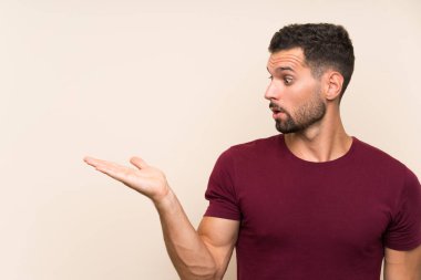 Avuç içinde copyspace hayali tutan izole arka plan üzerinde Yakışıklı adam