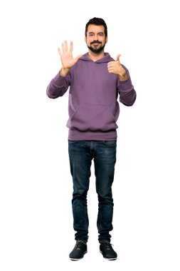 Eşofmanlı yakışıklı bir adamın tam boy fotoğrafı. Altı parmak sayıyor. Parmak izole edilmiş beyaz arka plan.