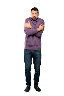 Eşofmanlı yakışıklı bir adamın izole edilmiş beyaz arka planda donarken tam boy fotoğrafı.