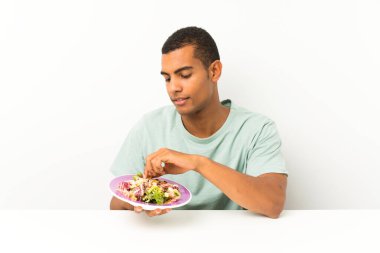 Bir masada salata ile genç yakışıklı adam