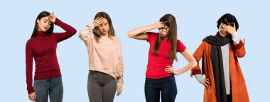 İzole edilmiş, mavi arka planda, yorgun ve hasta bakışlı bir kadın grubu.