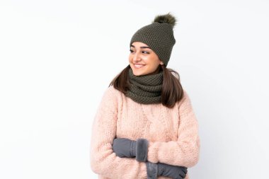 Kışlık şapkalı genç kız soyutlanmış beyaz arka planda gülüyor