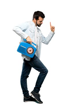 Bir radyo izole beyaz arka plan üzerinde tutarak sakallı yakışıklı adam tam uzunlukta atış