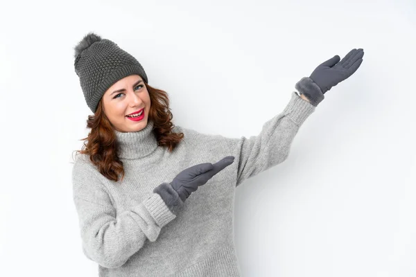 俄罗斯年轻女子 头戴冬帽 身披孤零零的白色背景 向旁边伸出手来 欢迎她的光临 — 图库照片