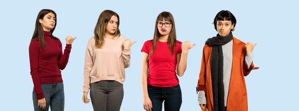 Conjunto Mujeres Sobre Fondo Azul Aislado Infeliz Apuntando Hacia Lado —  Fotos de Stock