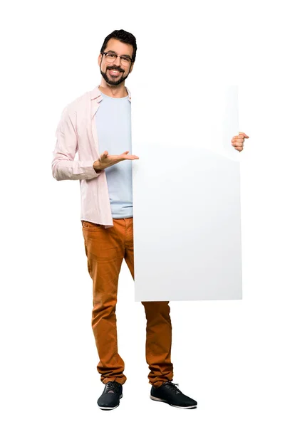 Homem bonito com barba segurando um cartaz vazio — Fotografia de Stock