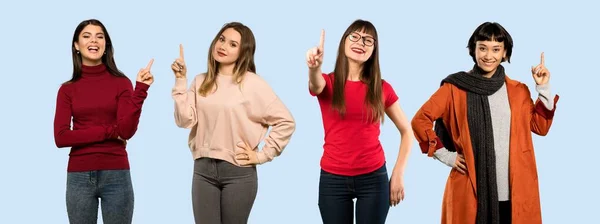 Conjunto Mulheres Sobre Fundo Azul Isolado Mostrando Levantando Dedo Sinal — Fotografia de Stock