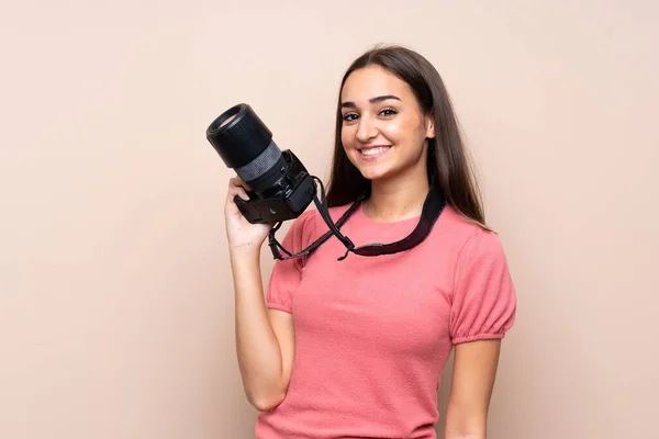 Mujer Joven Sobre Fondo Aislado Con Una Cámara Profesional —  Fotos de Stock