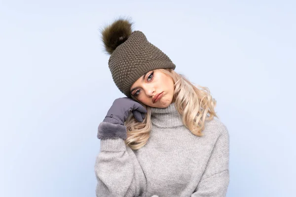 Giovane Ragazza Adolescente Con Cappello Invernale Sfondo Blu Isolato Infelice — Foto Stock